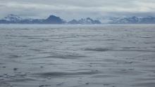 A dark ocean surface littered with ice, an inhospitable and remote location