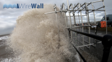 Overtopping water about to impact the WireWall system during a trial deployment at Crosby.